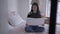 Wide shot front view of positive smiling young woman analyzing business project sitting on bed in home office. Shooting