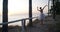 Wide shot graceful ballerina dancing on tiptoes on the right at background of sunrise at sea. Beautiful slim Caucasian