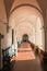 Wide shot of a hallway with red tiles and arched ceiling in an old building