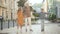 Wide shot of happy Caucasian grandfather strolling with cute boy and girl outdoors on sunny summer day. Cheerful grey