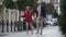 Wide shot happy cheerful girl with balloon walking jumping holding hands with granny outdoors. Excited Caucasian