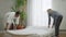 Wide shot of happy smiling couple making bed and lying down talking. Joyful carefree Caucasian woman and African