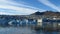 Wide shot of an iceberg with distant mountains in a clear sky