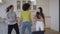 Wide shot of joyful multinational young women dancing in kitchen in slow motion. Happy carefree Caucasian African