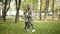 Wide shot of joyful slim woman and cute boy dancing on autumn meadow in park. Happy positive smiling Caucasian mother