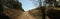 wide shot of long dirt dusty country road leading off into the distance on dry arid drought stricken agricultural farm land, rural