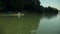 Wide shot of a man kayaking in lake very fast