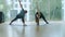 Wide shot of man and woman practicing yoga in gym. Portrait of male and female yogi doing exercises on exercise mat