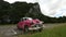 Wide Shot Of Pink Vintage Classic American Car Parked In Rural Lot In Cuba