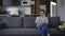 Wide shot portrait angry dissatisfied Caucasian woman sitting on couch thinking. Irritated anxious beautiful slim lady