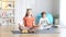 Wide shot portrait of cute Caucasian girl and boy sitting on exercise mat in lotus pose. Happy relaxed calm sister and