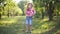 Wide shot portrait of cute redhead curly-haired little boy with ukulele posing in sunny summer spring park. Relaxed