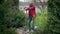 Wide shot portrait of exhausted tired young African American man standing with shovel in garden wiping forehead with