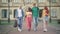 Wide shot portrait of group of happy university students walking and talking on campus. Cheerful Caucasian young men and