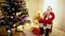 Wide shot portrait happy Father Christmas drinking hot milk sitting in rocking chair in living room. Relaxed bearded old