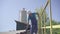 Wide shot portrait of professional factory worker walking along loading conveyor outdoors and checking valves. Manual