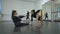 Wide shot of positive slim gorgeous women stretching warming up muscles in dance studio indoors talking in slow motion