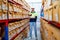 Wide shot of professional warehouse worker man stand with thumbs up and smiling to camera also stay between shelves of product