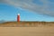 Wide shot of a red lighthouse in dunes of texel national park in netherlands