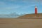 Wide shot of a red lighthouse in dunes of texel national park in netherlands