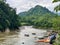 Wide shot of river and tropical mountains in Ecuador with rafting groups coming ashore.