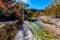 Wide Shot of a Rocky Stream Surrounded by Fall Foliage with Blue Skies at Lost Maples