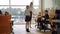 Wide shot of schoolgirl declaiming in classroom with teacher and classmates listening. Portrait of confident Caucasian