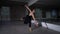 Wide shot serious young ballerina performing pirouettes looking in mirror in dance studio. Portrait of focused