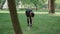 Wide shot of slim confident Caucasian woman in black sportswear and cap tying sneakers shoelaces, taking water bottle