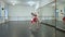 Wide shot of slim gorgeous Ukrainian young woman in national costume spinning in slow motion rehearsing dance in studio