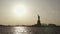 Wide shot of Statue of Liberty filmed in the sunset from the river in New York, United States of America