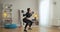 Wide shot of strong concentrated sportswoman doing squats holding barbell on shoulders. Portrait of slim beautiful