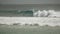 Wide shot of surfers riding a wave at kirra