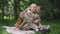Wide shot thoughtful beautiful military woman in uniform sitting on picnic as cheerful teenage boy hugging in slow