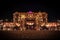 Wide shot of tropical trees and ground water fountains near Emirates Palace at night in Abu Dhabi