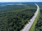 Wide straight toll highway M-11passing in forests. View from above. The Moscow-Saint Petersburg motorway designed as the M11 Neva