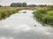 Wide stream in a Dutch polder landscape