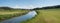 Wide stream valley with mowed grassland