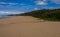 Wide Stretch of Beach Leading up to Vegetation Covered Dunes