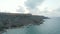 Wide View of Coastline of Gozo, Malta Island at Sunset with Cliff and Ocean Waves, Aerial reverse dolly backwards