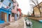 Wide view on colorful houses from a secondary street in Burano island during a cloudy winter day