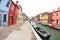 Wide view on colorful houses from a secondary street in Burano island during a cloudy winter day