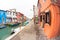 Wide view on colorful houses from a secondary street in Burano island during a cloudy winter day