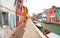 Wide view on colorful houses from a secondary street in Burano island during a cloudy winter day