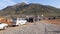 Wide view of a crowd of people and vehicles moving on the dusty road of the mountain