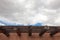 Wide view detail of red adobe exterior with beans, wood slats, blue sky with clouds