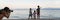 Wide view image of beautiful family moment on the beach at  dusk