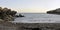 Wide view of a rocky beach at sunset. Cove, inlet.