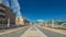 Wide walking street in the tourist resort Playa de las Americas. Super wide angle panoramic view. Clear sunny day with very few