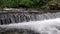 Wide waterfall on a mountain river in dark summer day Foamed water Falling waterfall